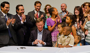 National Jewish Health President and CEO Michael Salem, MD, several students from the Kunsberg School and others share a laugh after the governor signed a law establishing a tax credit for contributions to Kunsberg and other hospital-based schools.
