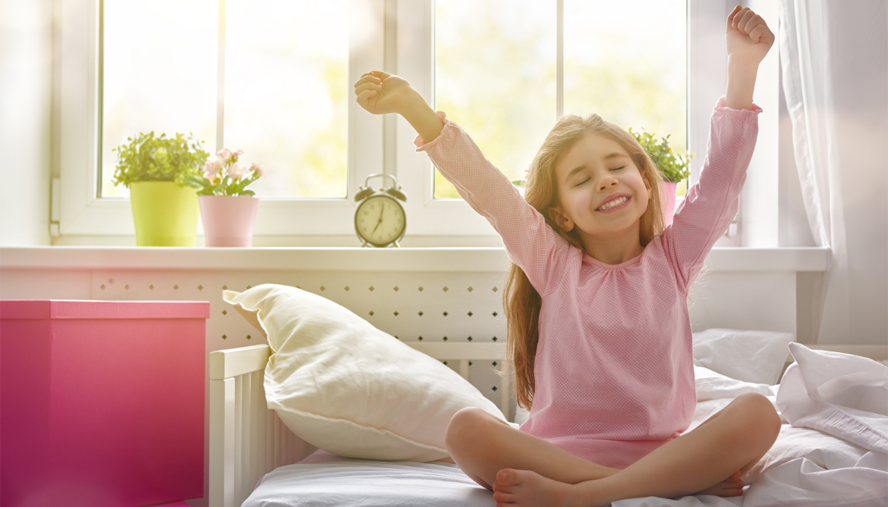 Child stretching in front of sunlit window