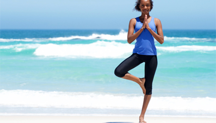 woman doing yoga at the beach