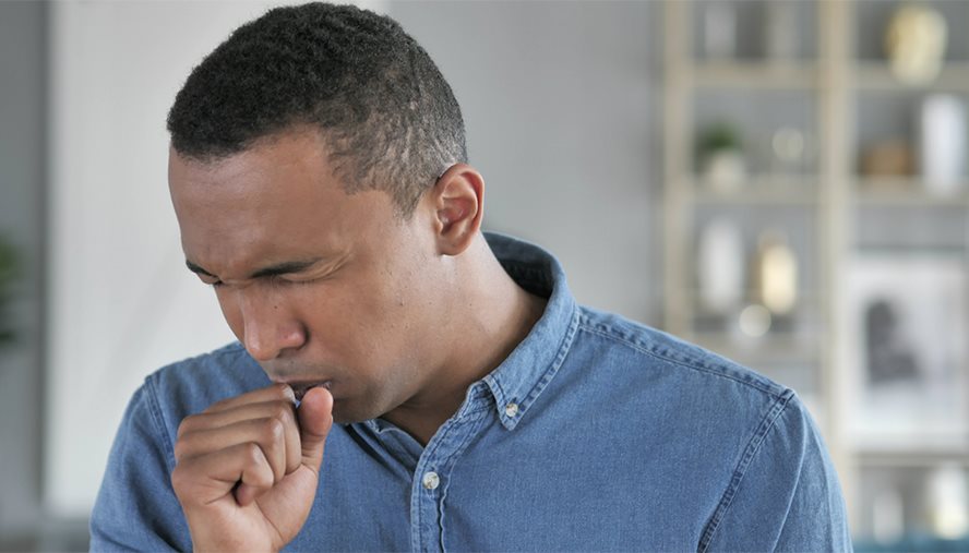 man coughing into hand