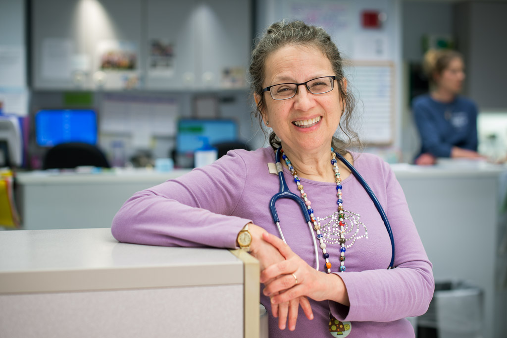 Nurse standing at a desk smiling