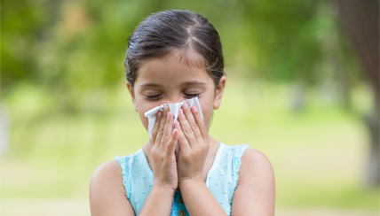 child blowing her nose