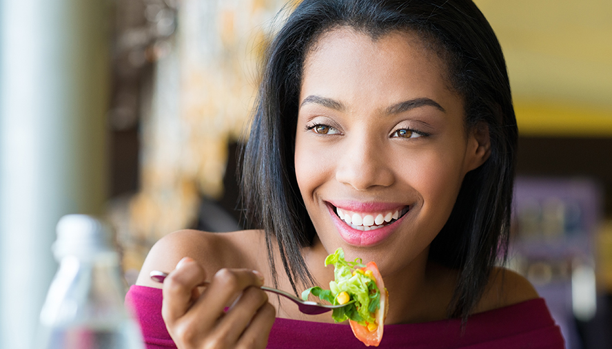 Woman happily eating lunch salad