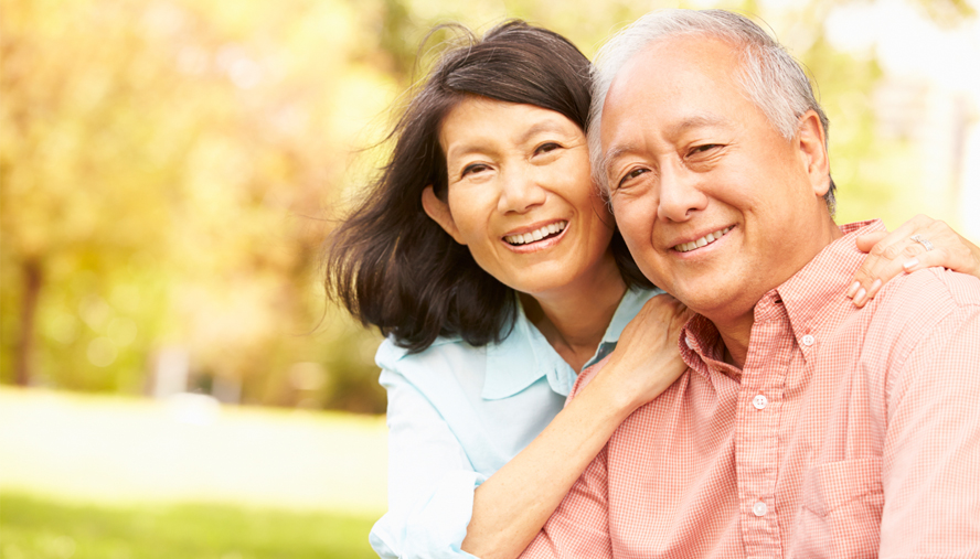 Elderly couple hugging.