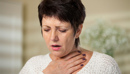 woman grasping throat