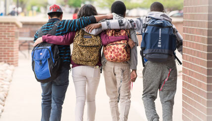 Four teens with arms on shoulders