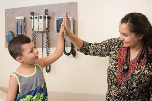 Child giving high-five to doctor